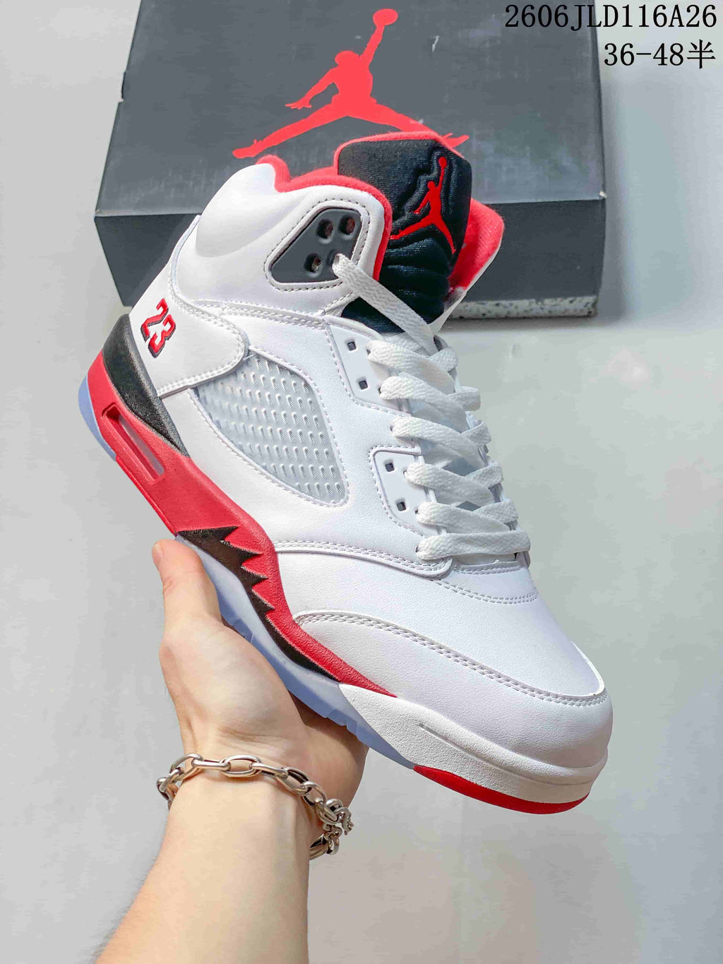 Side view of a white high-top sneaker with red and black accents