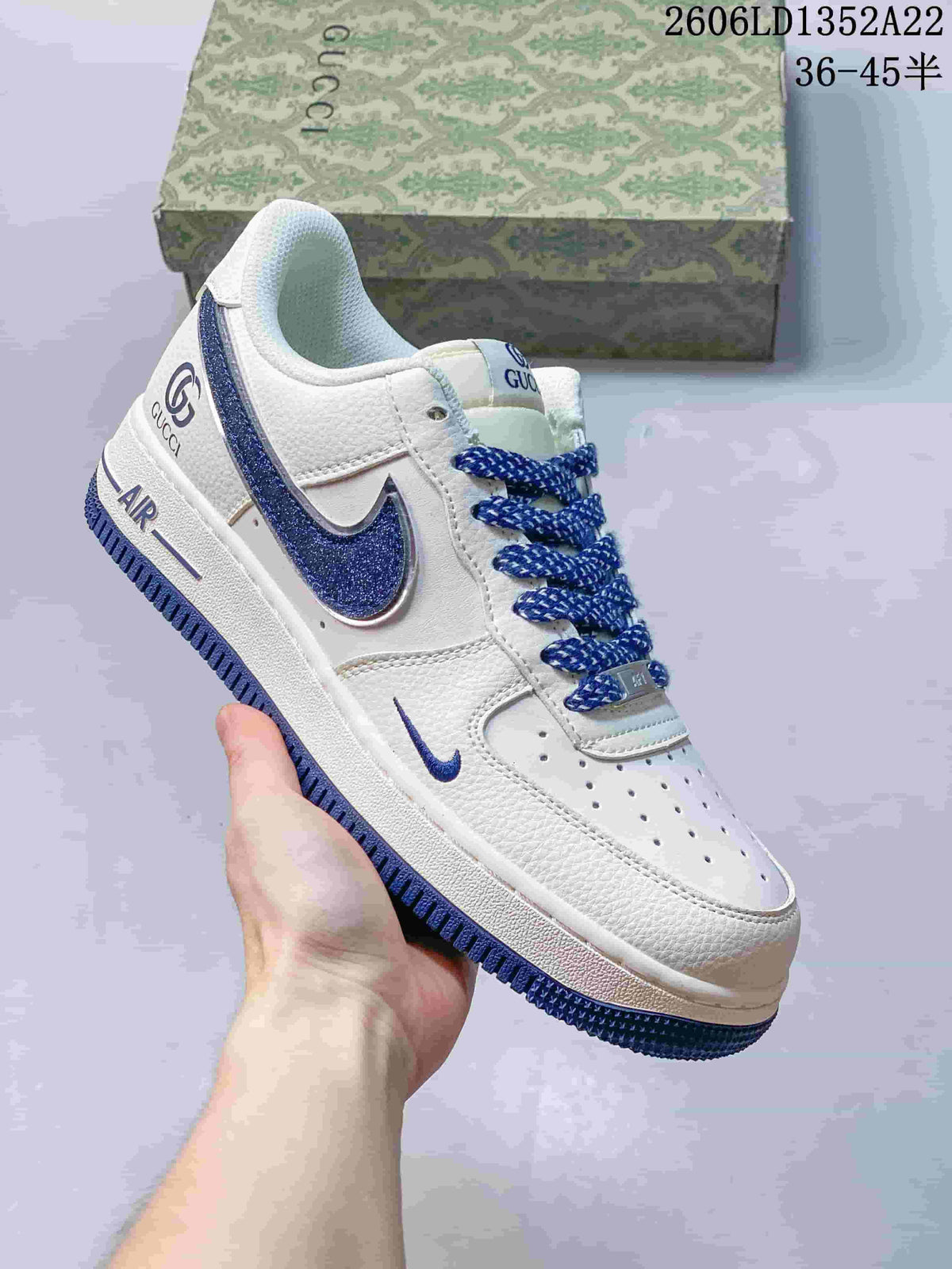 Angled view of a white and blue low-top sneaker with perforated toe and Gucci branding; image text shows style code 2606LD1352A22 and size range 36–45.5.