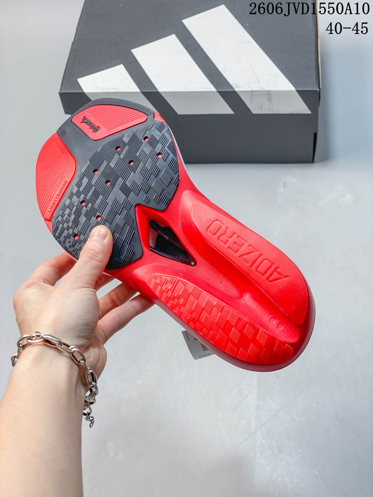Underside of a red running shoe showing a patterned black and red outsole.