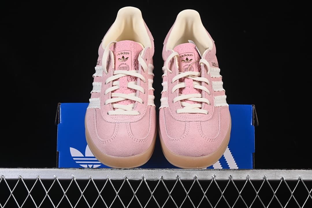 Front view of the pink sneaker pair displayed on the blue shoebox