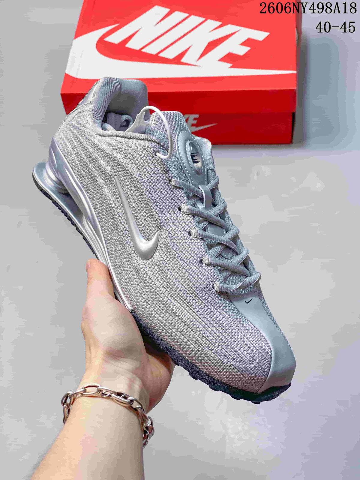 Close side view of a silver Nike Shox TL sneaker with metallic Swoosh