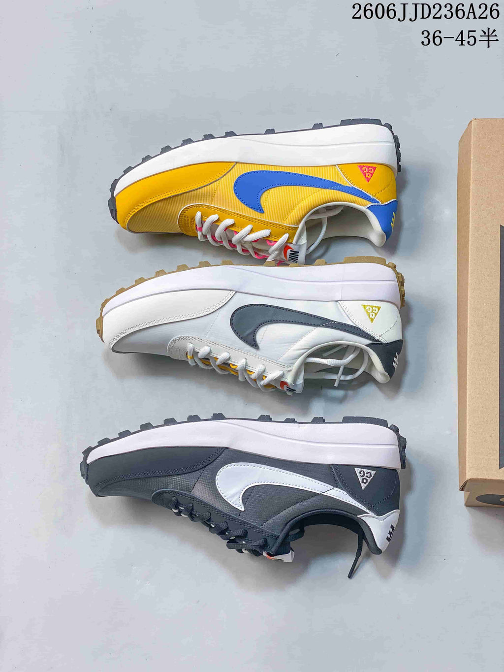Pair of charcoal Nike ACG LDV sneakers with white Swoosh detailing, shown on a box.