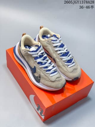 Pair of beige and blue sneakers displayed on an orange box; sample-size marking 36–46½ is visible.