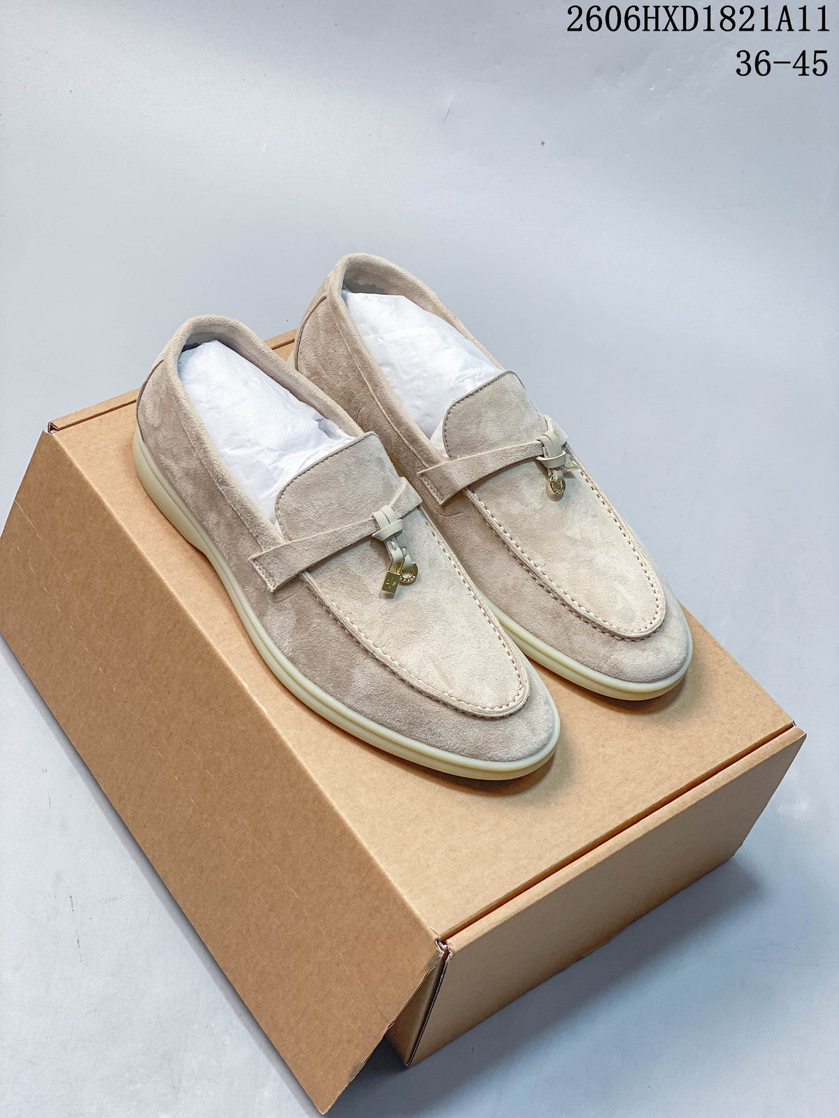 Pair of beige suede-style Loro Piana lock-detail loafers shown from above on a box.