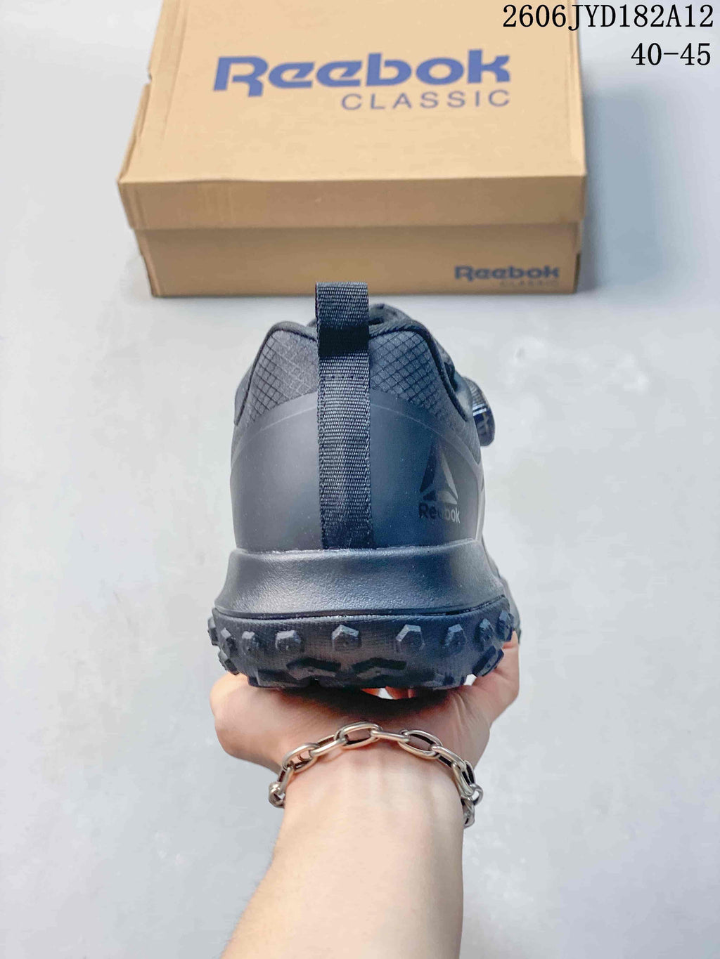Rear view showing the heel and tread of a charcoal low-top sneaker.