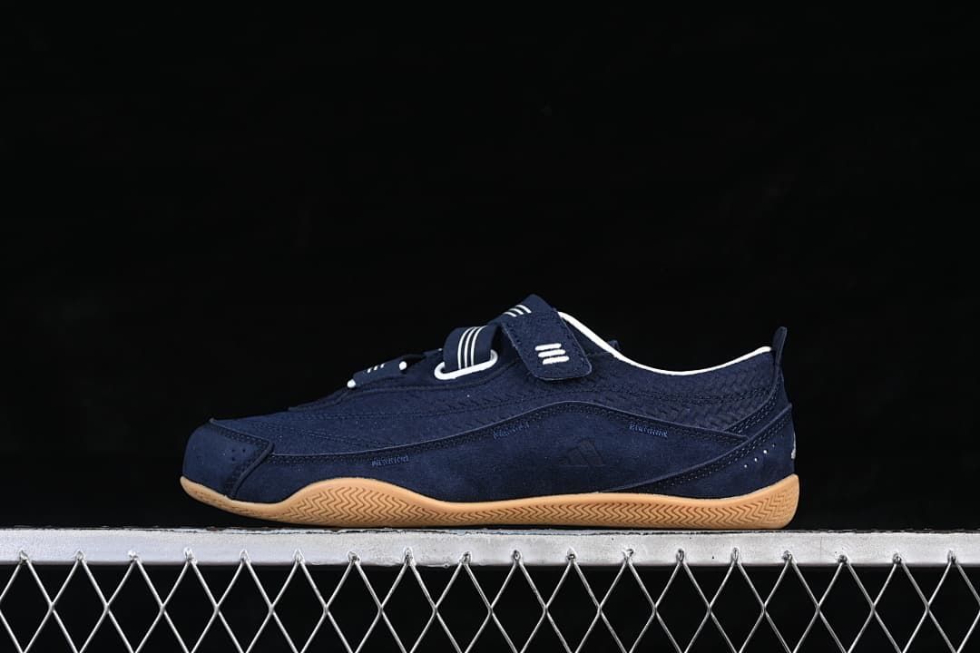 Side view of the navy sneaker with striped straps and gum-colored sole.