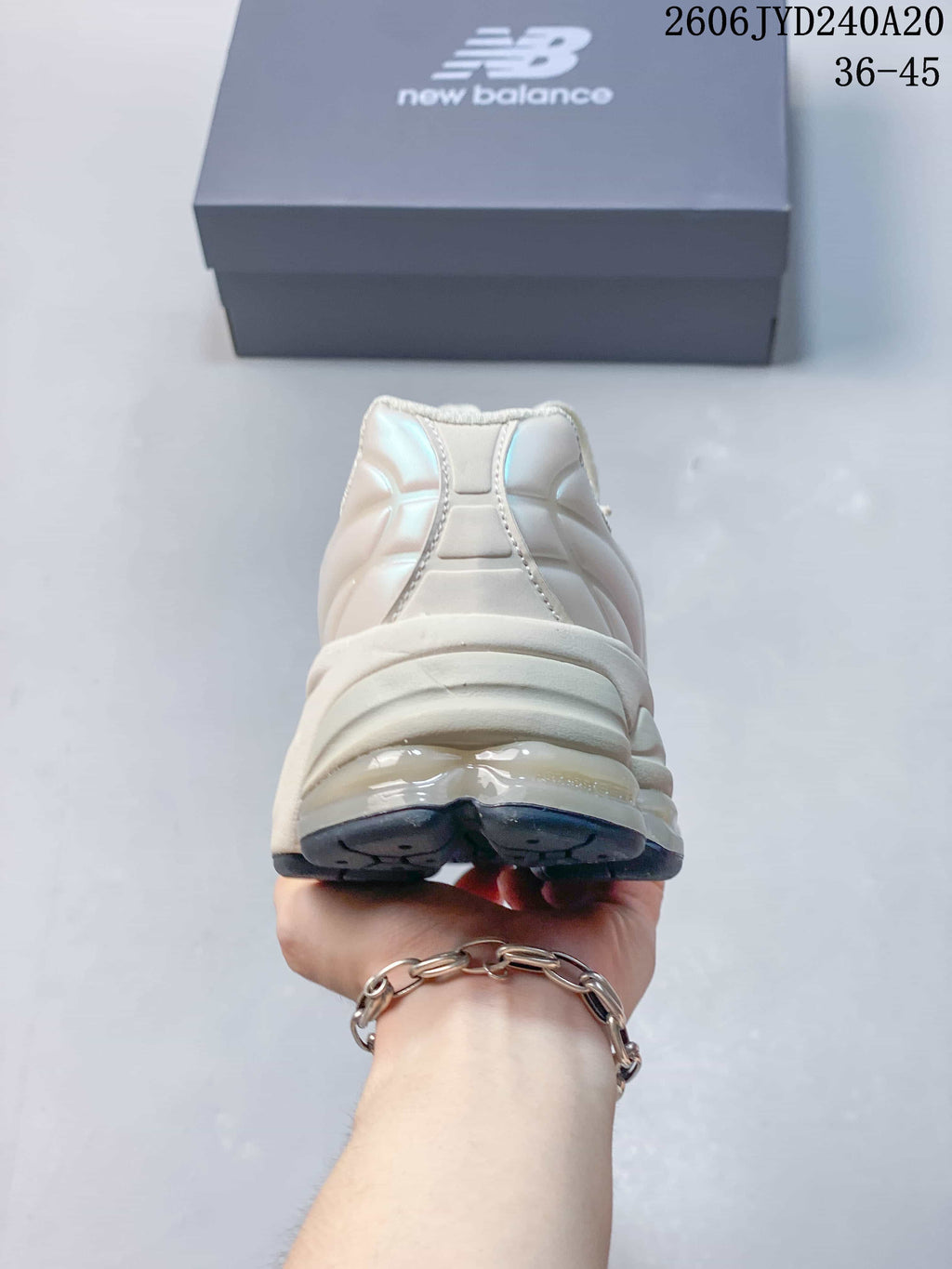 Rear view of a pearl-white sneaker with a layered heel and dark outsole.