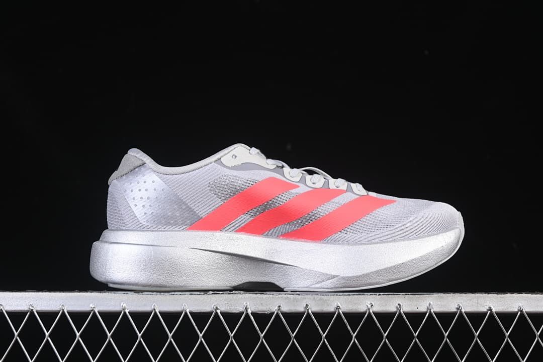Side profile showing the gray upper, coral stripes, and thick midsole