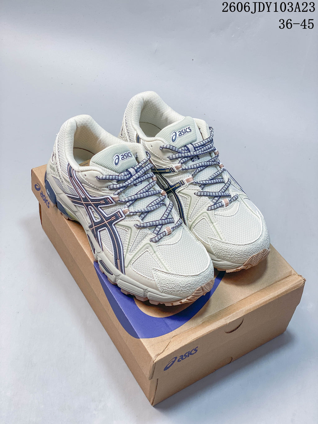 Pair of cream ASICS Gel-Kahana 8 sneakers with navy accents displayed on a shoe box