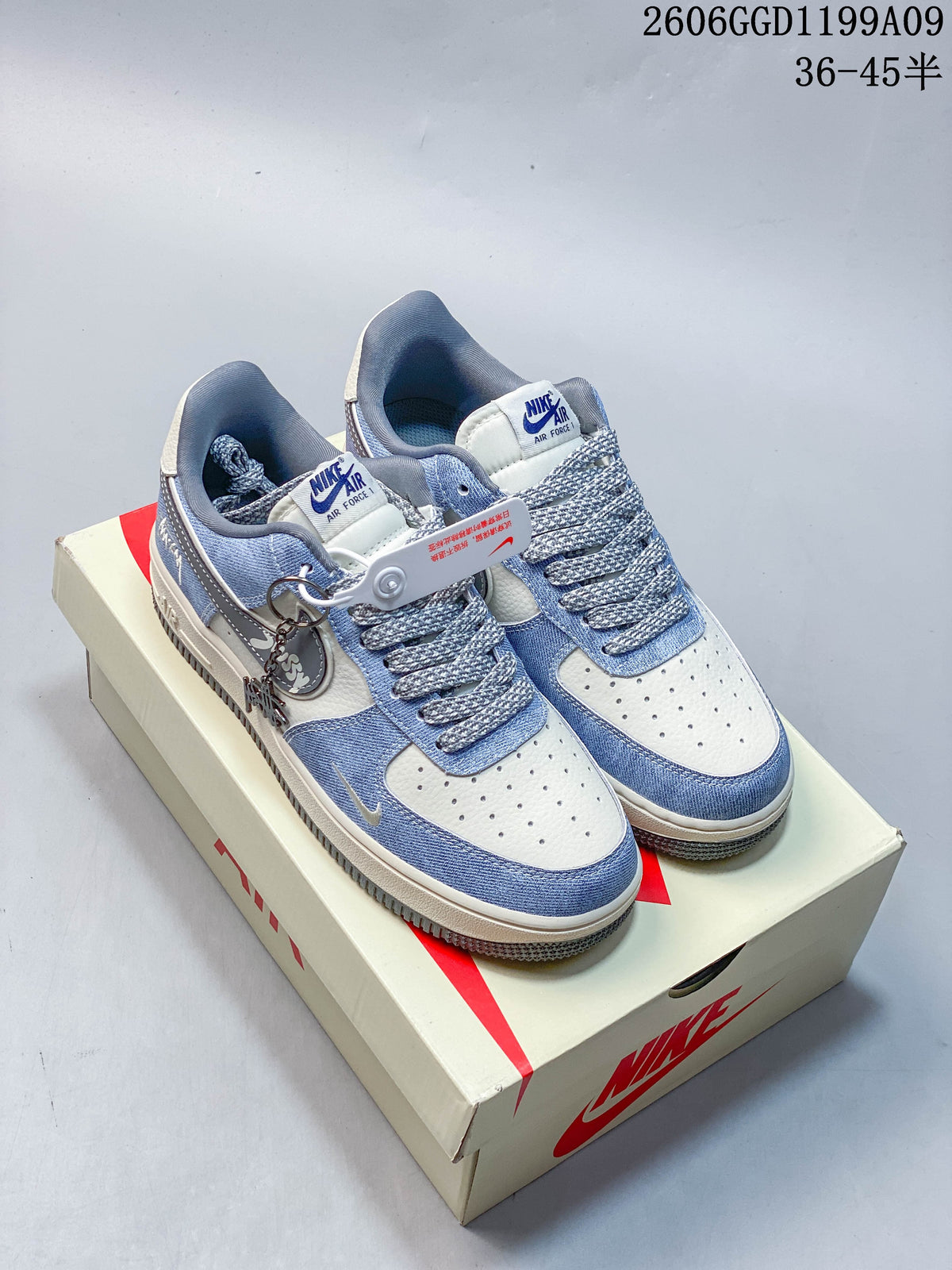 Pair of pale blue and off-white Nike Air Force 1 Low-style sneakers with patterned laces and a decorative charm.