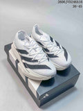 Pair of white Adidas Adizero Prime X 3.0 Strung running shoes with black stripes, shown on a shoebox