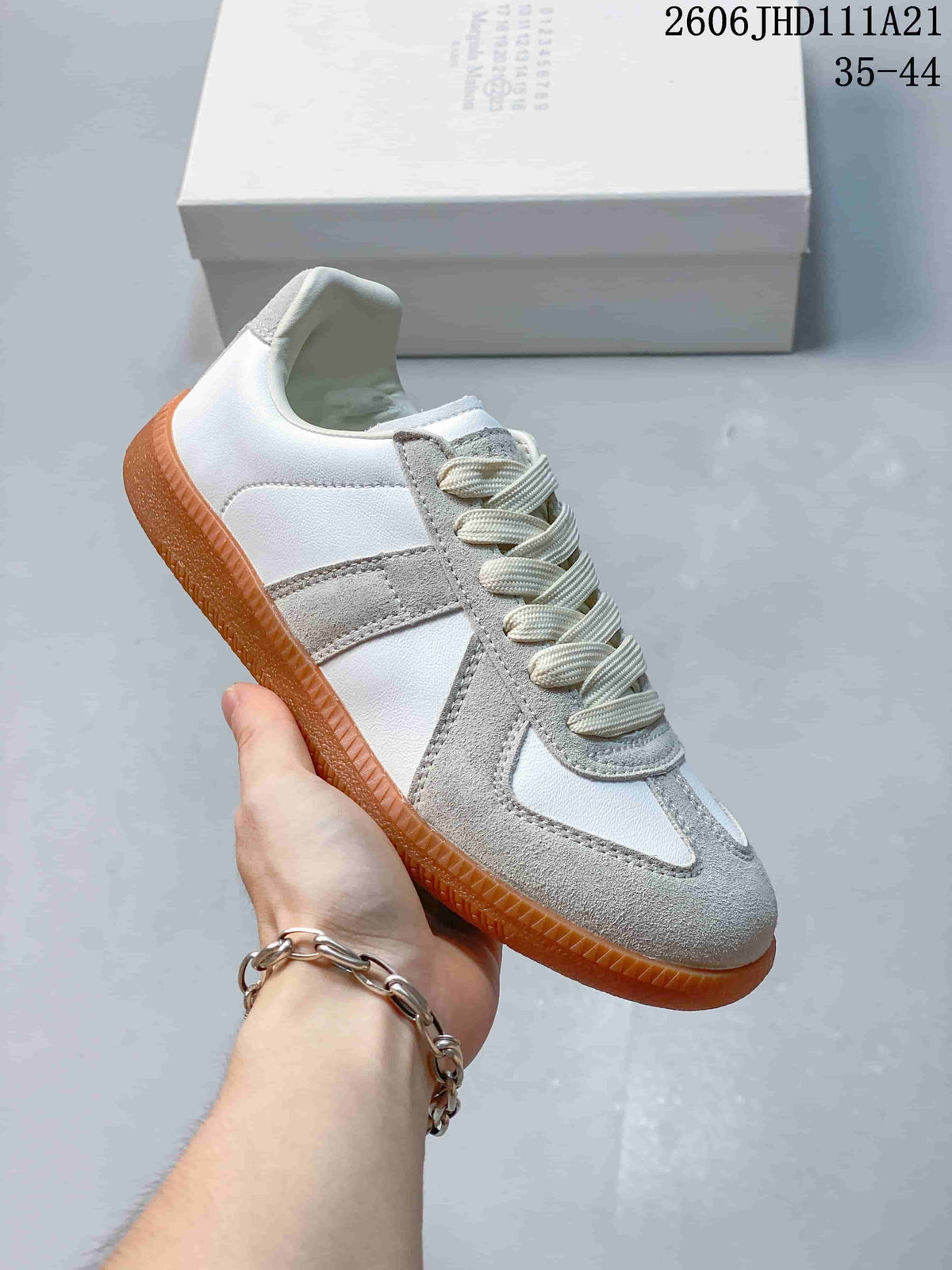 Side view of a white and gray low-top sneaker with a gum-colored sole