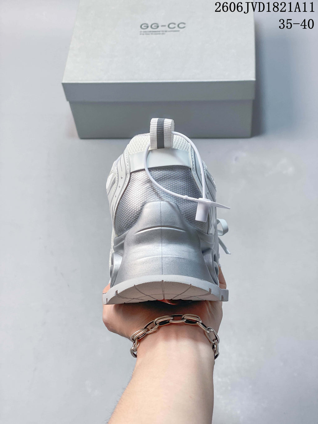 Rear view of a white sneaker with a silver-toned heel section