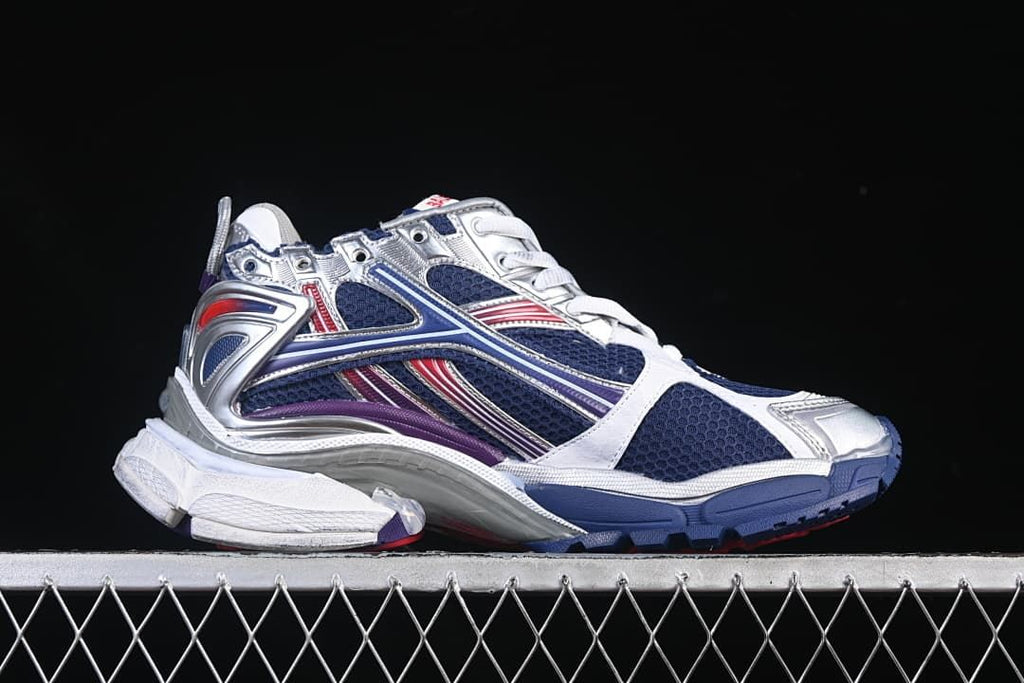 Side view of the sneaker with navy panels and silver, red and purple accents