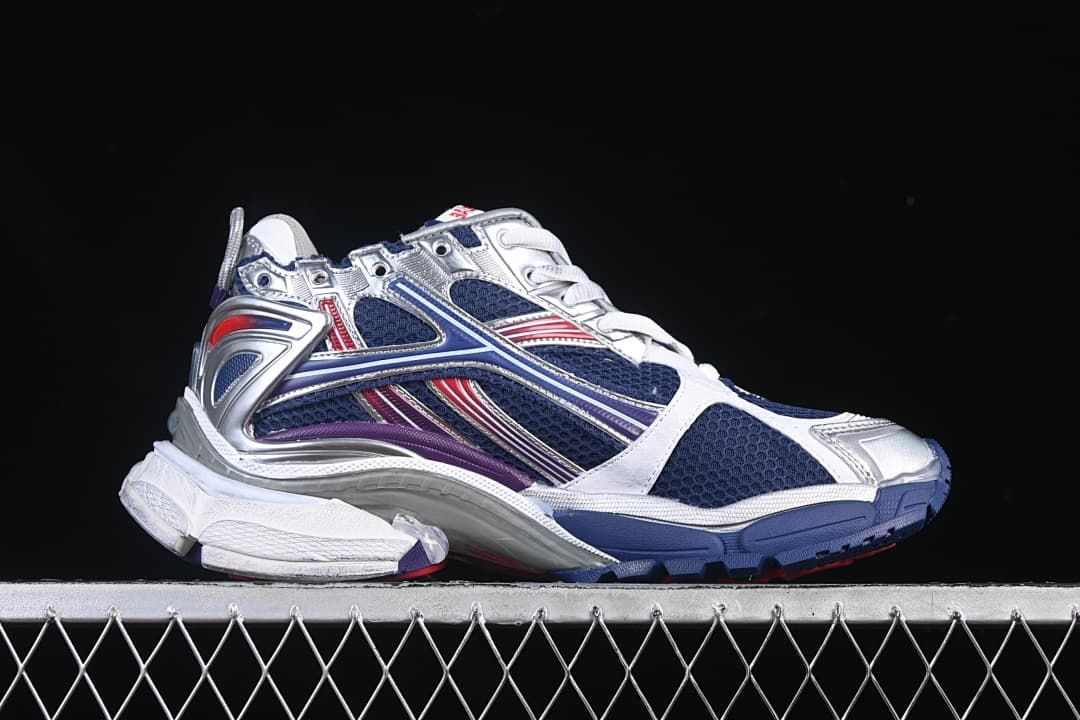 Side view of the sneaker with navy panels and silver, red and purple accents