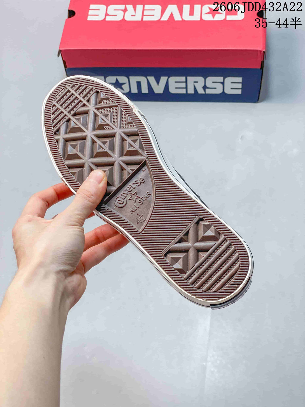 Textured outsole of a Converse All Star sneaker beside its box