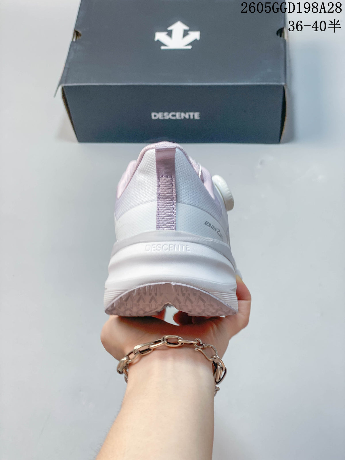 Rear view showing the heel and thick sole of a DESCENTE running shoe.