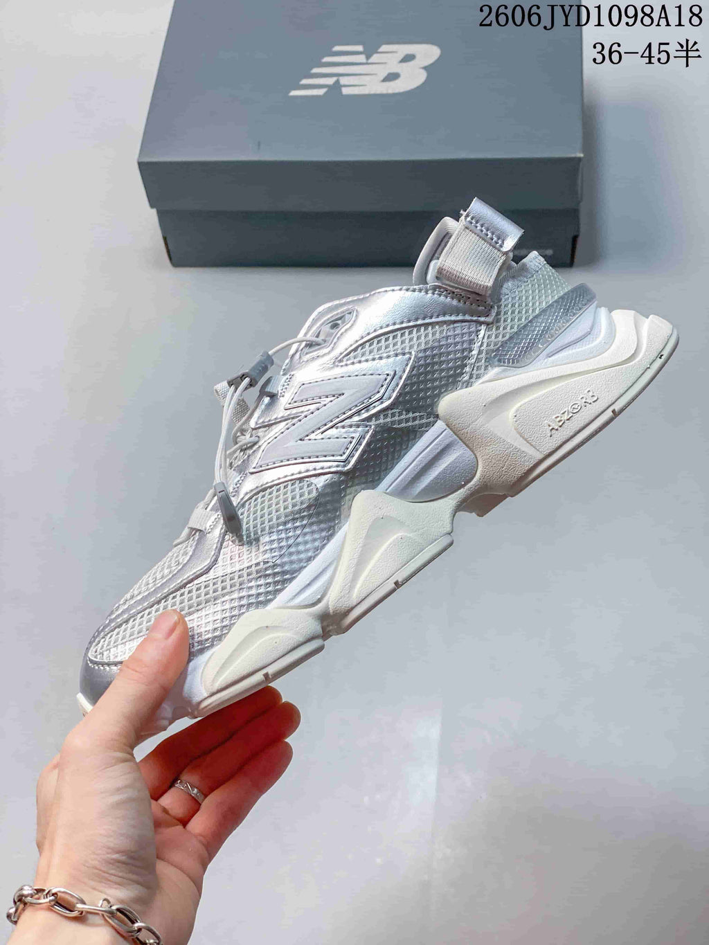 Side view showing the layered silver upper and sculpted white sole.