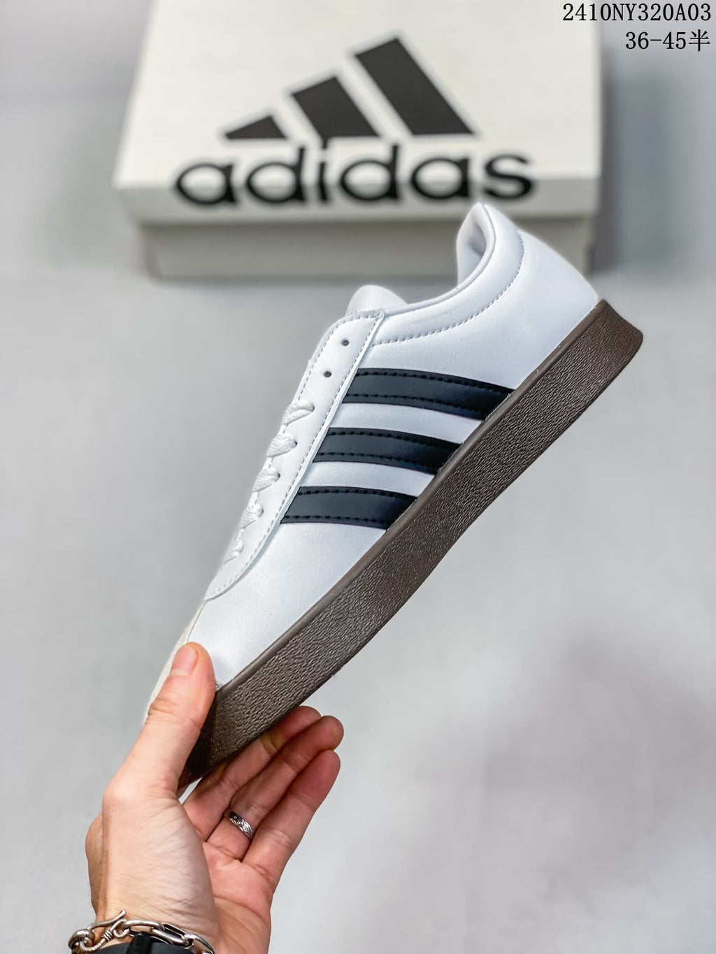 Side view of the white low-top sneaker with black stripes and a dark brown sole.