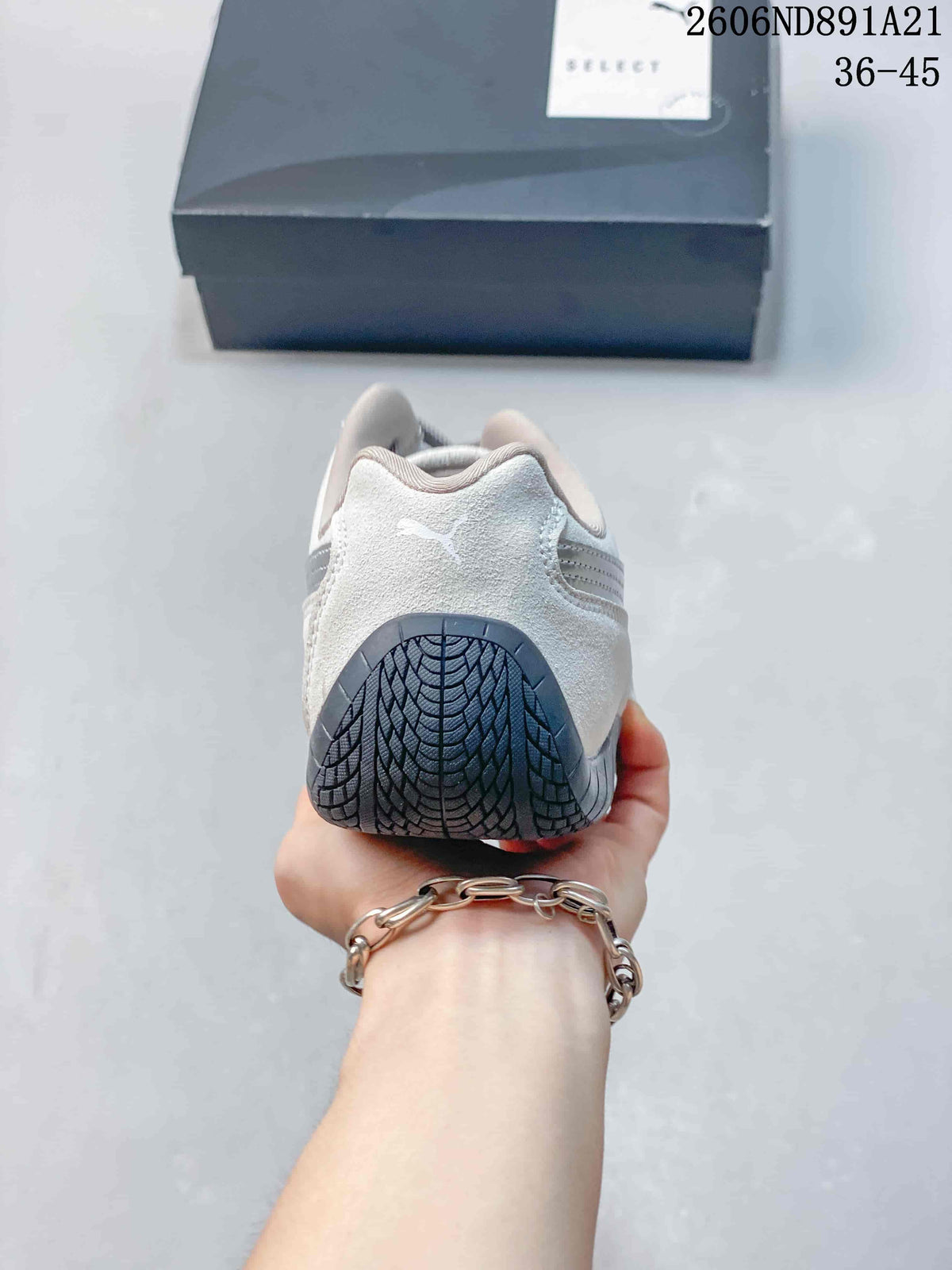 Rear view showing the heel and dark outsole of a light gray Puma Speedcat OG sneaker