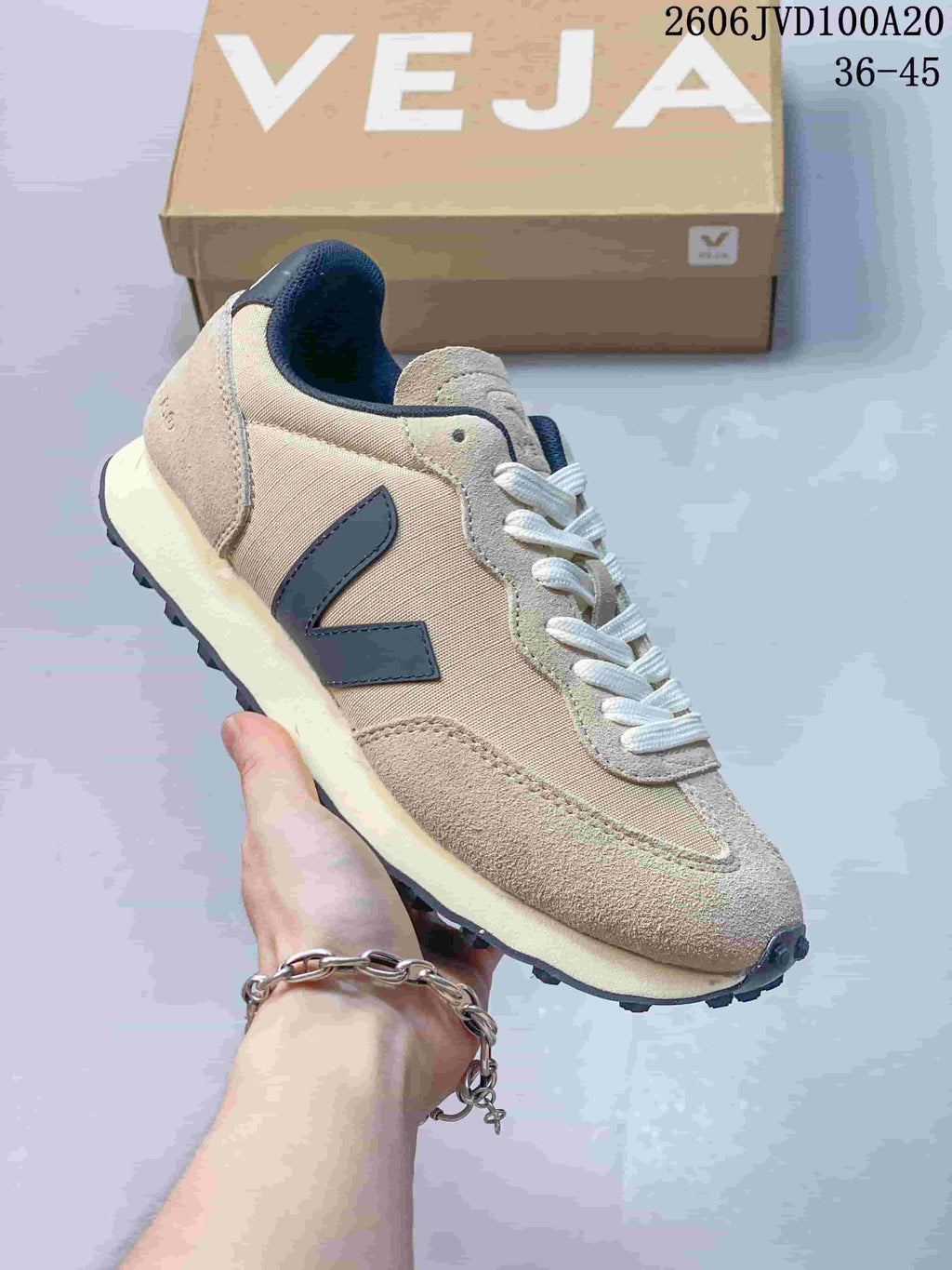 Angled side view of the beige and navy Veja low-top sneaker