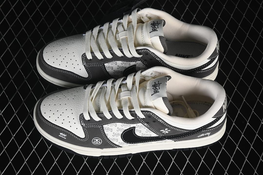 Pair of white and grey low-top sneakers with black Swooshes and patterned side panels