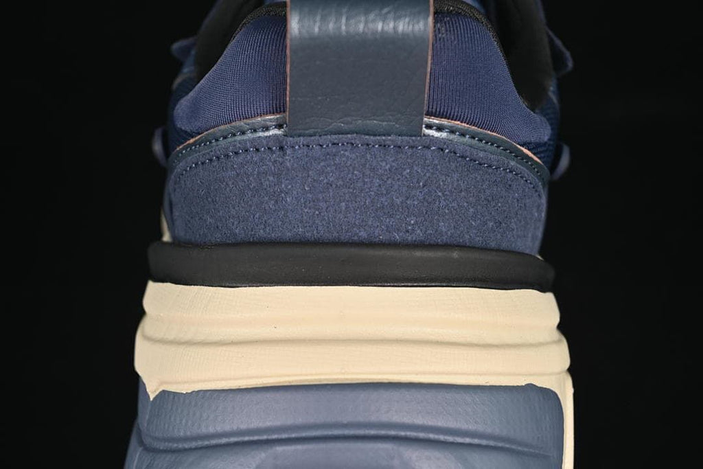 Rear close-up of the navy sneaker with layered cream and blue sole details