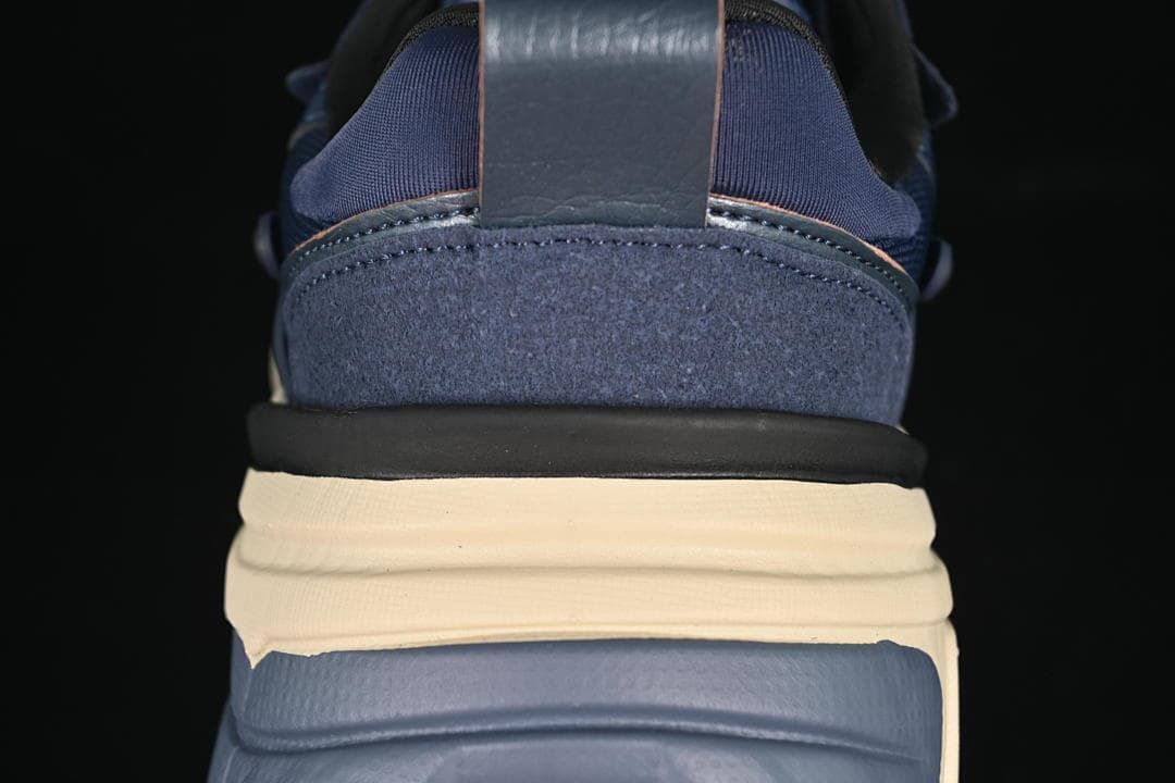 Rear close-up of the navy sneaker with layered cream and blue sole details
