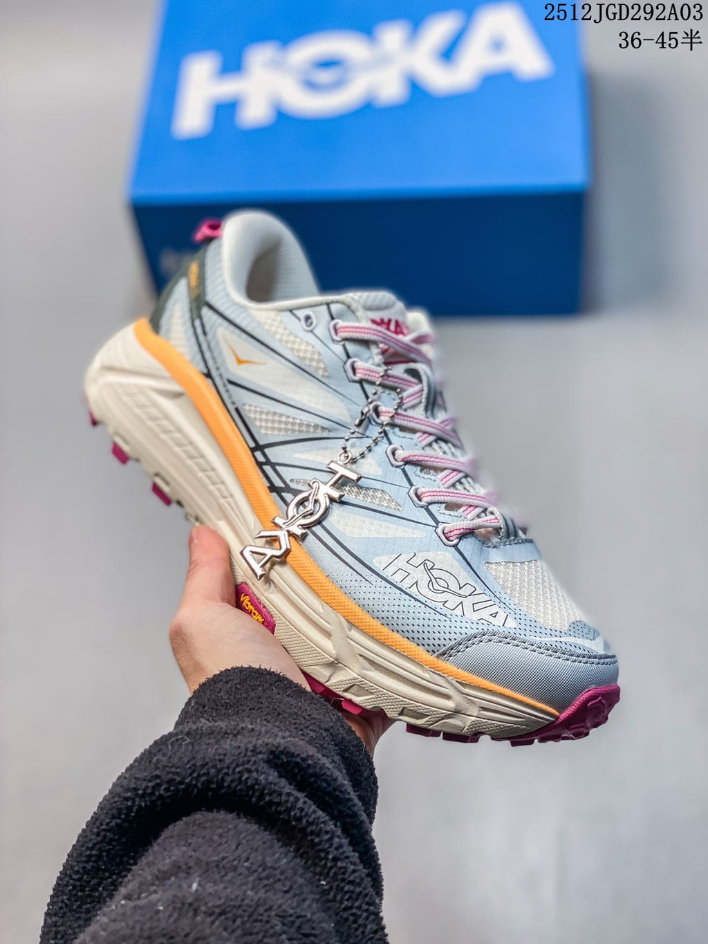 Side profile of a light blue HOKA Mafate Speed 2 shoe with pink laces and orange trim.