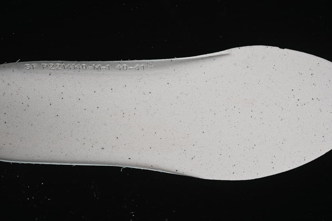 Close-up of a light-colored shoe insert with printed markings