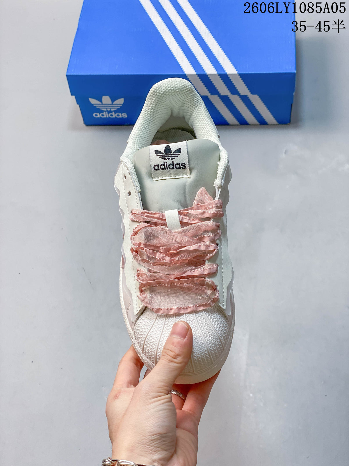 Front view highlighting the shell toe and decorative pink lace detail.