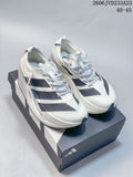 Pair of white adidas Adizero Prime X3 running shoes with dark patterned stripes, displayed on a shoe box