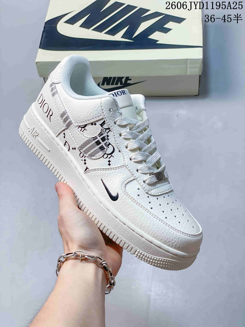 White low-top sneaker with dark printed side panels, perforated toe, and lace-up front