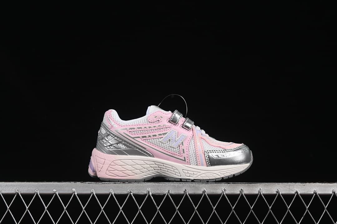 Side profile of a pink and silver kids’ sneaker with two fastening straps.