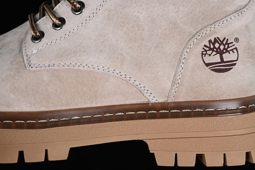 Close-up of side logo, stitching, and lugged outsole