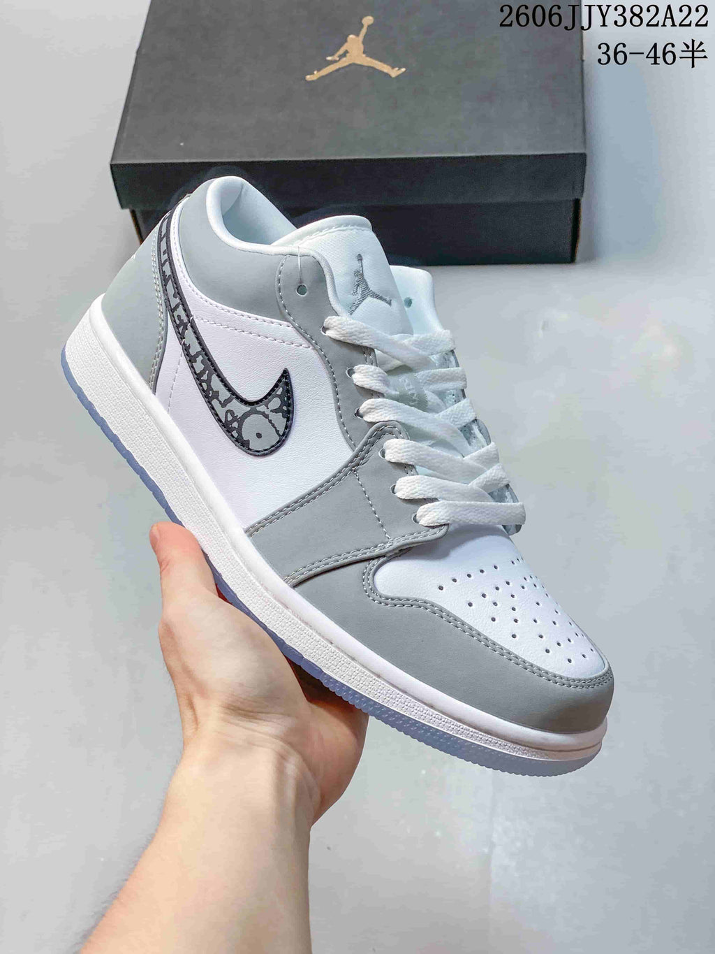Angled side view of the white and grey low-top sneaker with patterned Swoosh