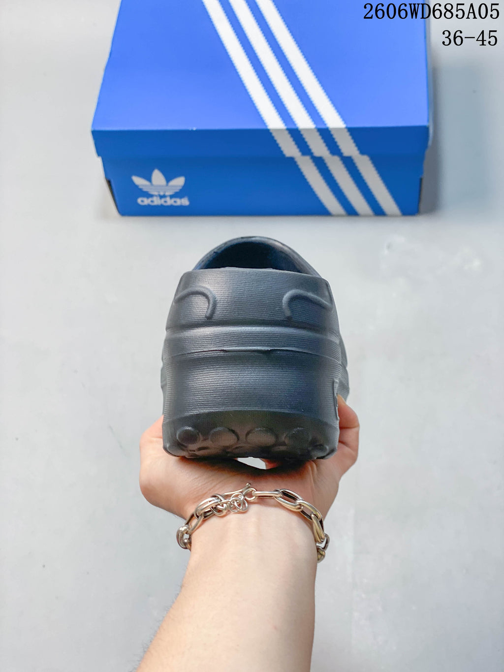 Rear view showing the raised heel and rounded outsole of the mule