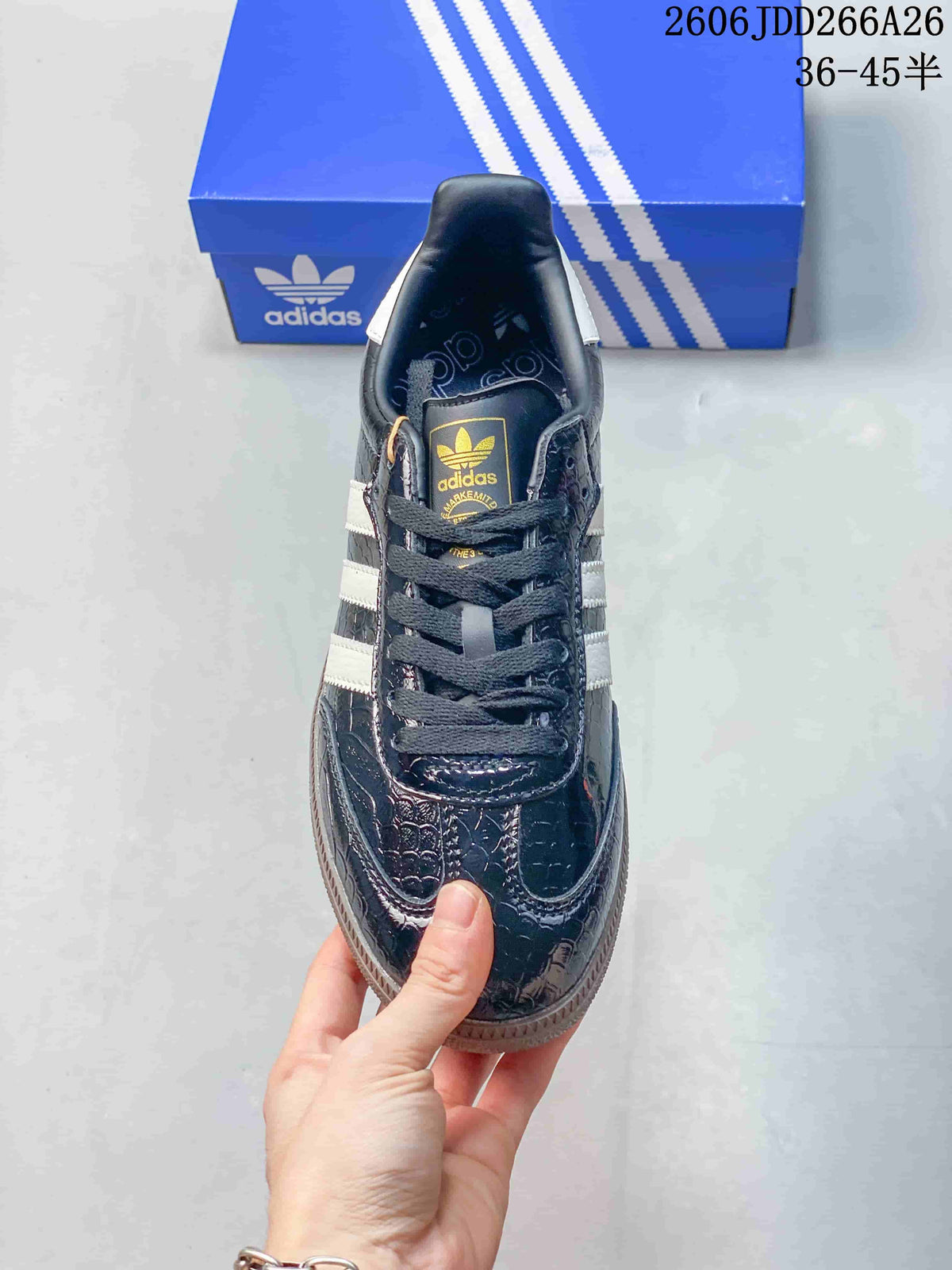 Top view of the dark Adidas Samba sneaker showing its laces, patterned upper, and tongue logo.