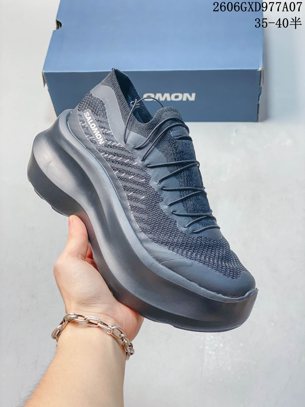Angled side view of the gray sneaker with Salomon branding and a raised sole.