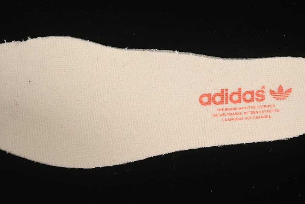 Close-up of a light-colored insole printed with adidas branding