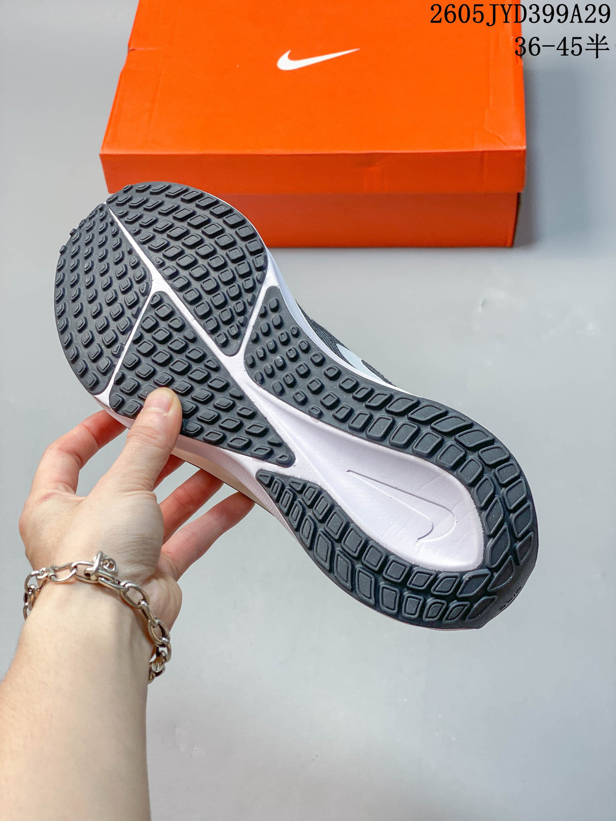 Underside of the grey running shoe showing its patterned outsole