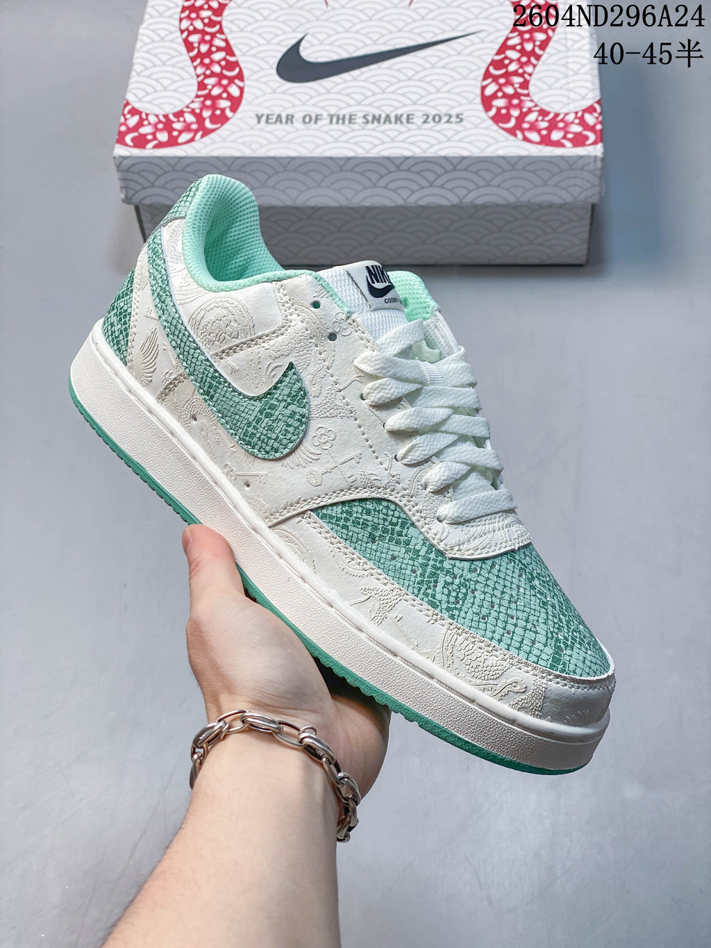 Close view of a green and off-white Nike Court Vision Low sneaker with patterned accents