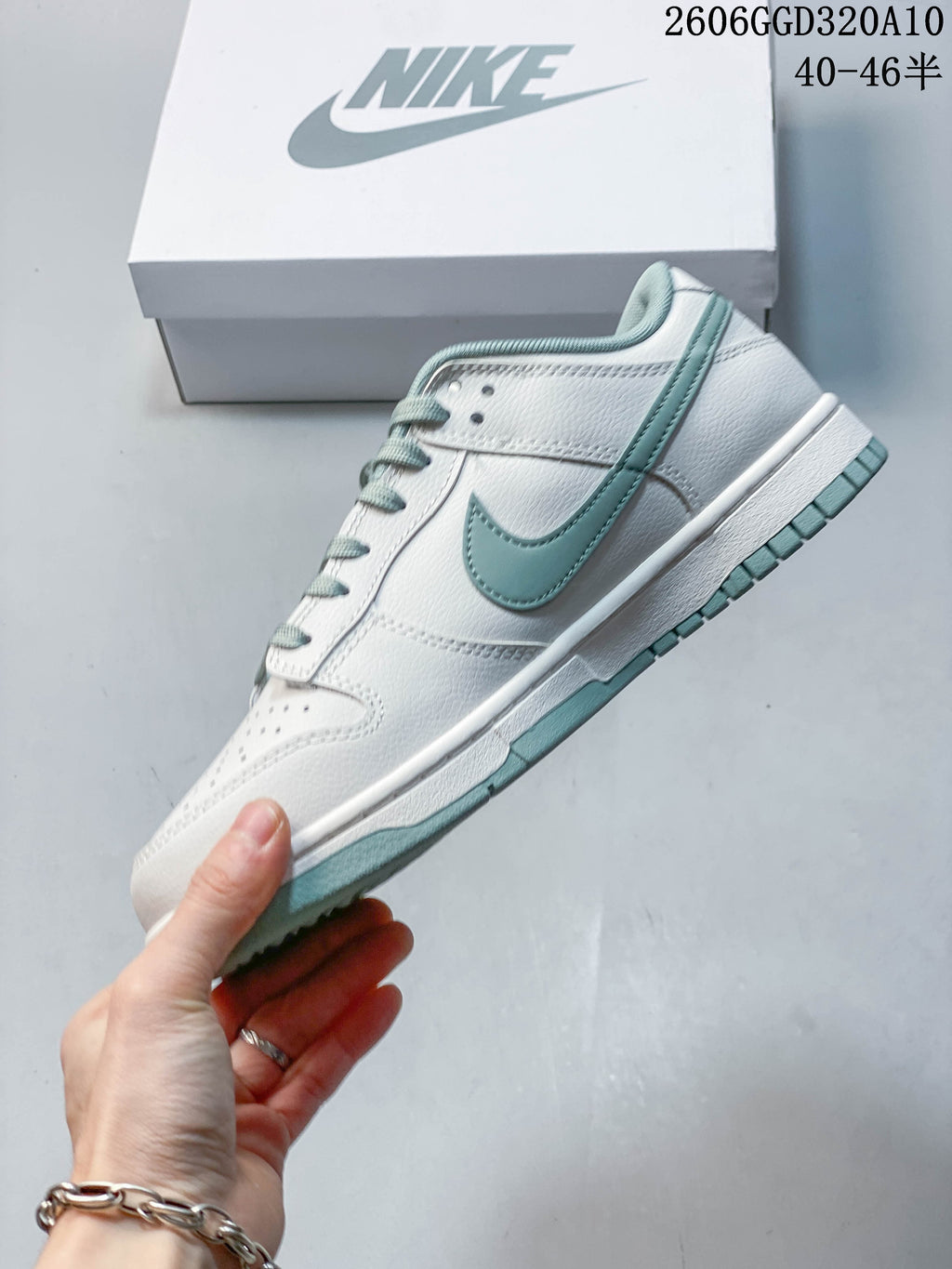 Side view showing the white panels and sage Swoosh on a Nike Dunk Low Retro sneaker.