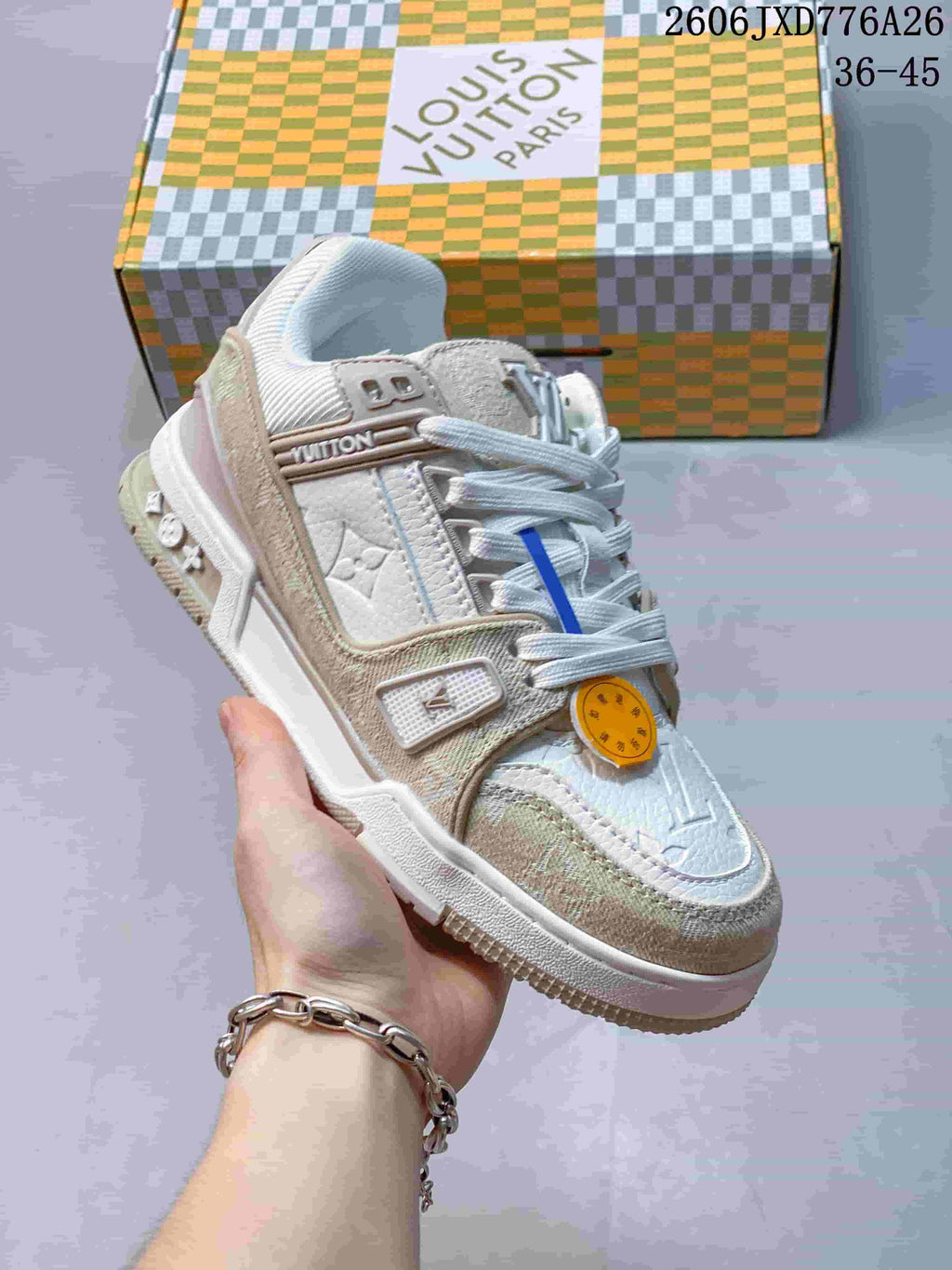 Close-up of a white and beige Louis Vuitton Trainer Low sneaker with textured panels