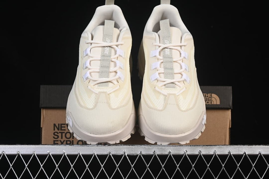Front view of the pair of shoes with the labeled box behind them