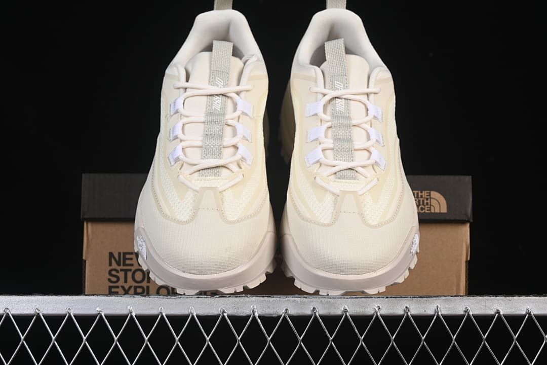 Front view of the pair of shoes with the labeled box behind them