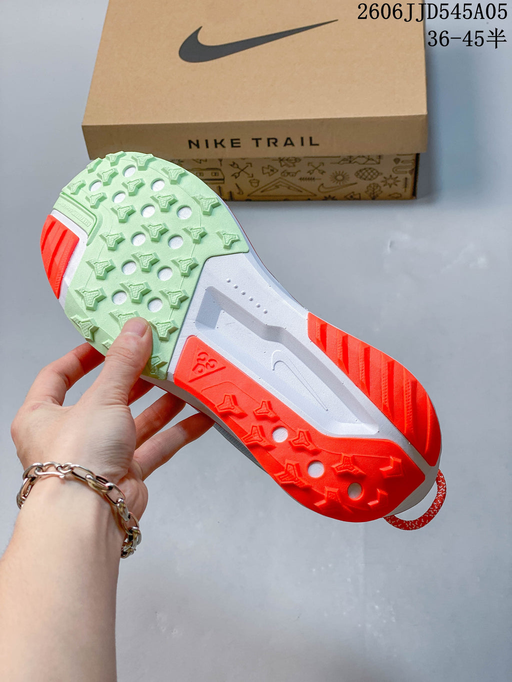 View of the patterned outsole with pale green and bright red-orange sections.