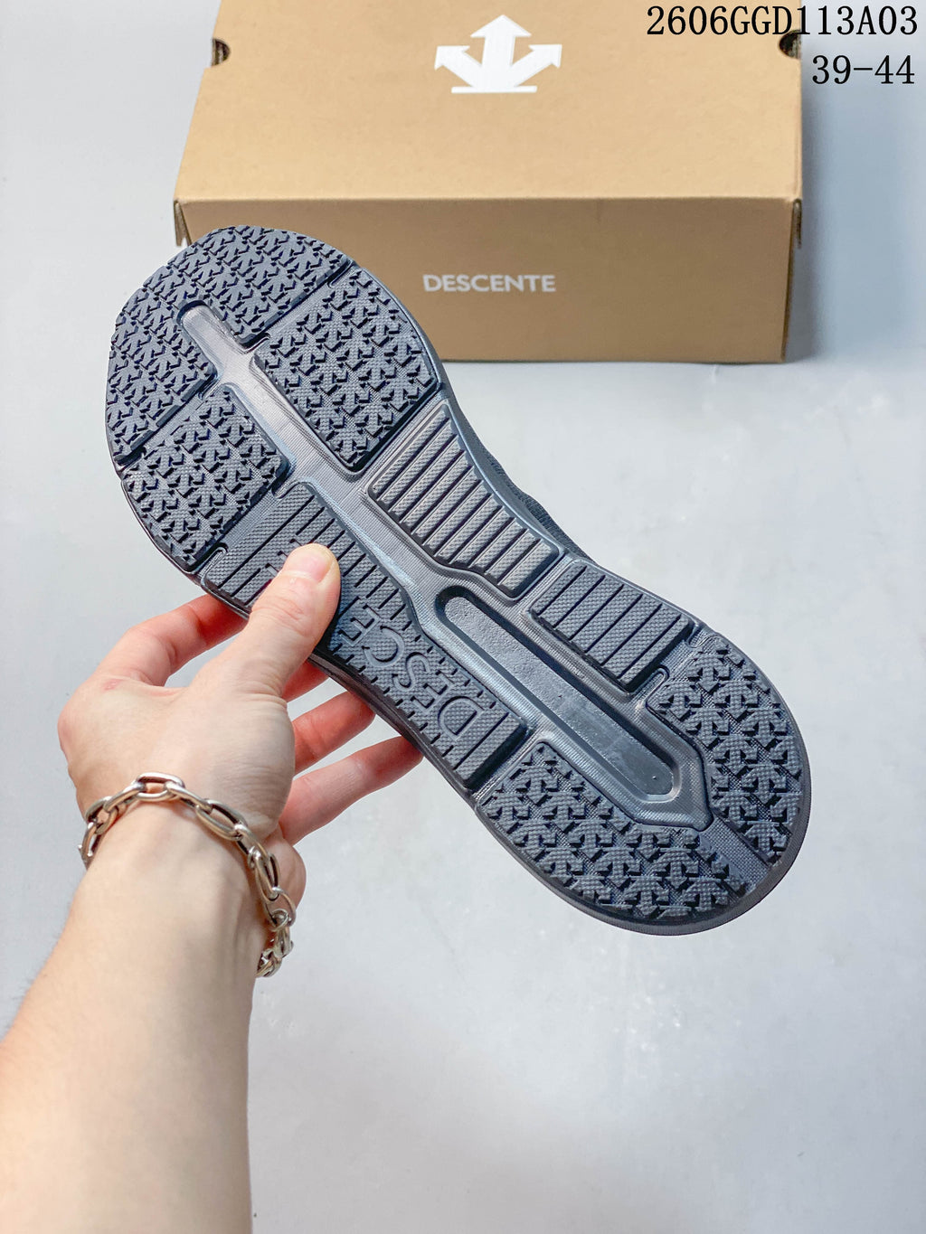 Close-up of the textured outsole on a gray DESCENTE shoe