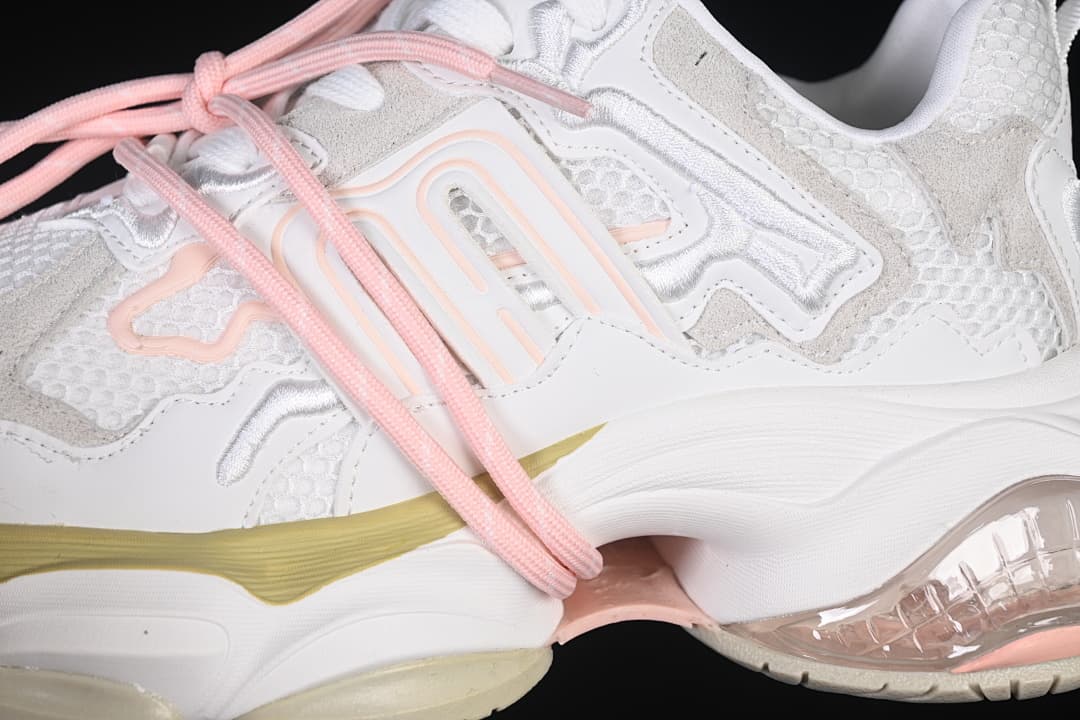 Close-up of the side overlays, mesh panels, pink laces, and pale yellow accent.
