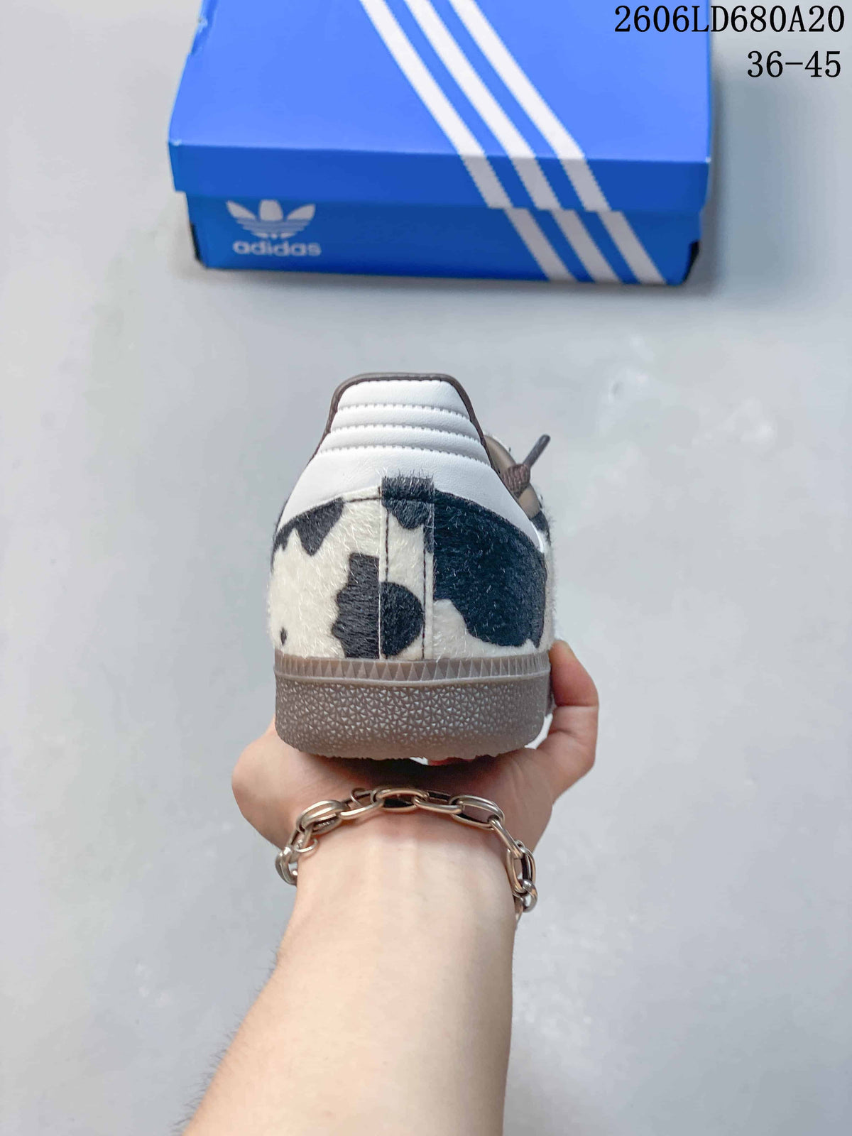 Rear view of a cow-print sneaker showing the heel and gum-colored sole